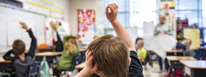 A child has a question in an elementary classroom