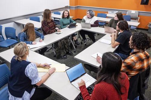 Classroom with eight students sitting around a table with im体育.